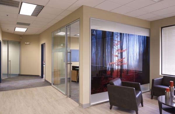 Clestra showroom office. Glass front office is installed with P81 Profile framing. Wall shows sliding glass door, office has a window decal.