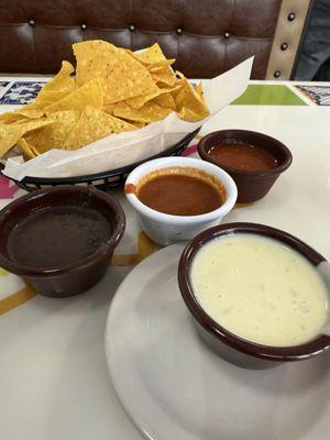 Chips and ti dips included: bean, hot salsa, cold salsa. Also pictured at additional cost, queso.