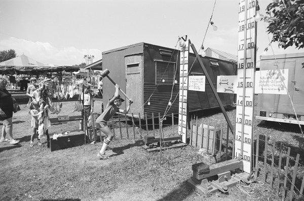 Boy swinging mallet at the carnival at the Sweet Corn Festival. - - -Tom Brody