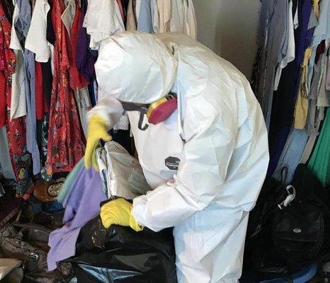 Technicians are removing contents from a bio hazard containment. The containment was set up in a living room.