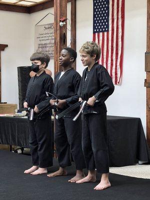 Youths receiving their Black Belt