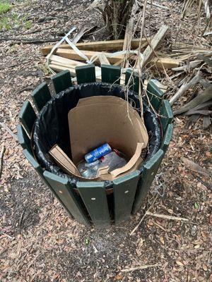 No cover on trash can so trash spread through park