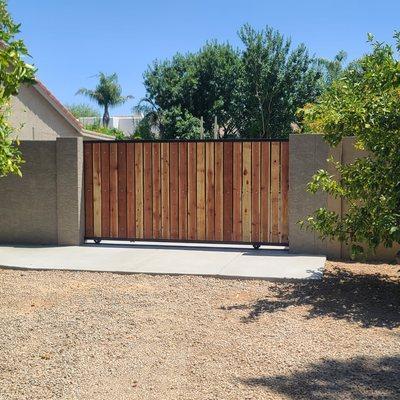 4x8x16 fence block wall with a slide gate with 5.5" redwood boards.