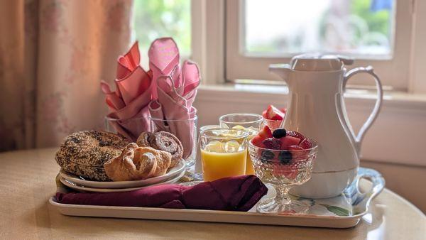 Breakfast of fruit, pastries, and juice