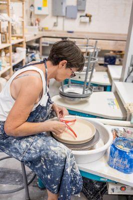 studio member working independently at a pottery wheel