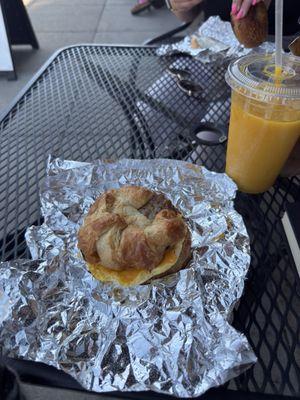 Egg and Cheddar Croissant with sausage and a mango smoothie.