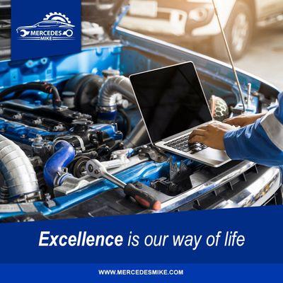 A professional automotive technician works on a car engine using a laptop for diagnostics, surrounded by high-performance com...