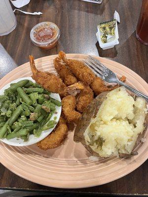 Fried shrimp, baked potato and green beans