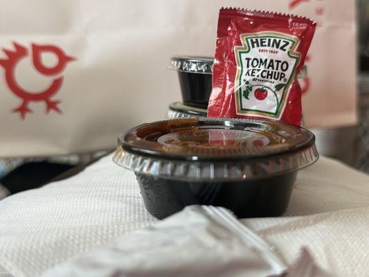$1 for this tiny cup of sauce (ketchup packet for scale)