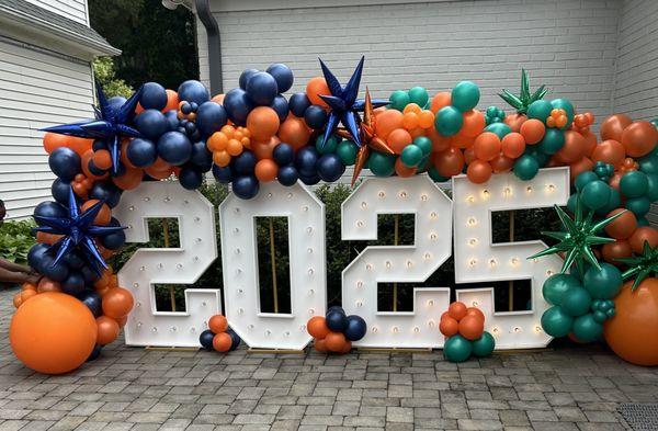 balloon garland, blue, orange and green with lighted marquee letters.
