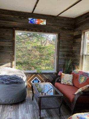 Tree House view of North interior wall, picture window and solar eclipse stained glass
