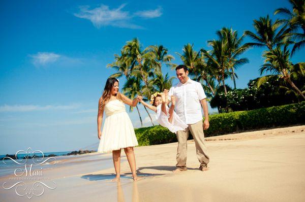 Photographers in Maui capturing candid moment of family having fun.