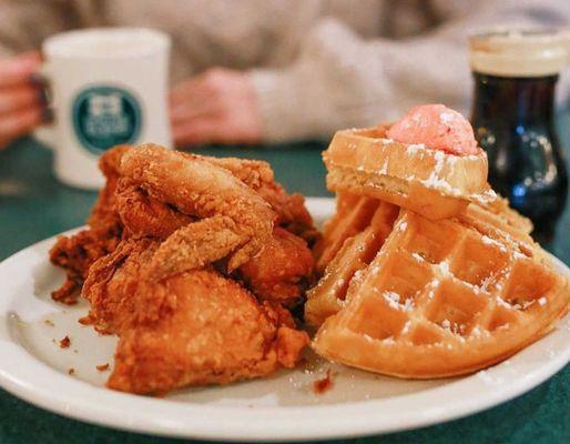 Our famous Fried Chicken & Waffle - half a fried chicken alongside a fluffy Belgian waffle, topped with sweet strawberry butter