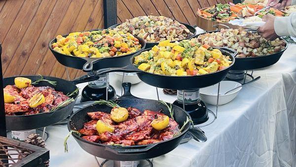 Buffet table loaded up and ready to go, barbecue chicken in foreground