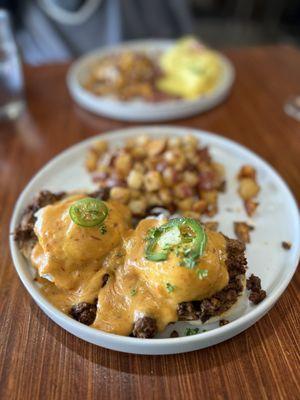 Chorizo eggs Benedict and hubbys in the background.