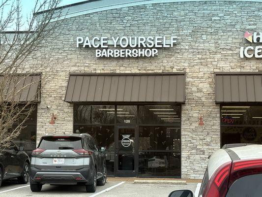 view of front entrance of barbershop (facing southward, from parking lot)