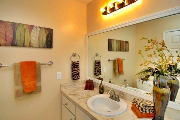 Even dated bathrooms benefit from staging. Buyer's eyes are drawn to the accent pieces as opposed to the dated bathroom cabinet.