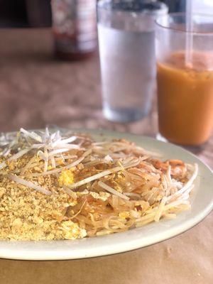 Shrimp pad Thai & Thai iced tea (background)