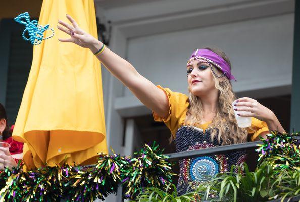 Tossing Mardi Gras Beads from the Bourbon Street Balcony at Cornet