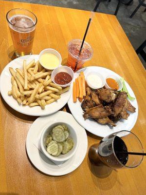 French fries, chicken wings with buffalo sauce on side, drinks