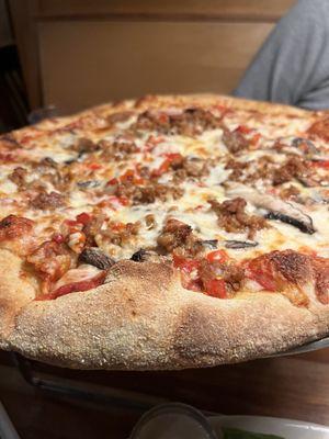 Whole wheat pizza with home made sausage, roasted red peppers, portobello mushrooms , mozzarella cheese and marinara sauce