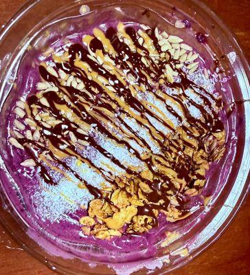 Açaí bowl with granola , coconut macaroons , sunflower seeds with peanut butter and chocolate drizzle