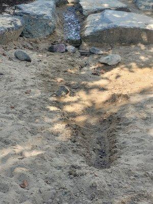 Exposed drain pipe in a sand pit
