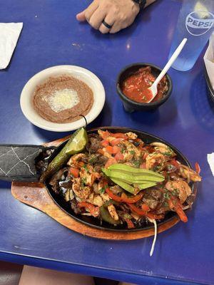 Fajitas mixtas with shrimp, chicken beef mixed with bell peppers, onion, tomatoes