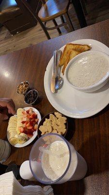 Oatmeal with toast, side fruit such as banana slices, strawberries, animal cookies, pecans, raisins.
