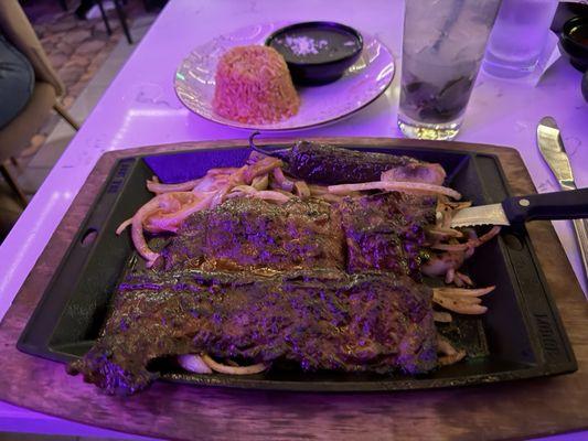 Carne Asada over grilled onions with rice and beans