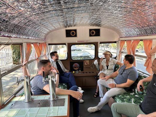 Adults enjoying drinks while the kids play in the back yard.