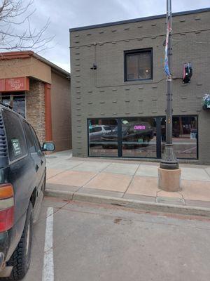 Walk between the buildings to the side door