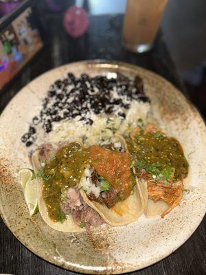Carnitas taco, carne asada taco, & chicken tinga taco with a side of black beans & cilantro lime rice.