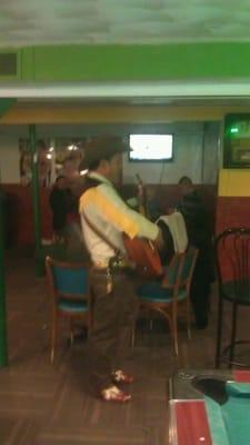 A man and his guitar singing, putting in a show.