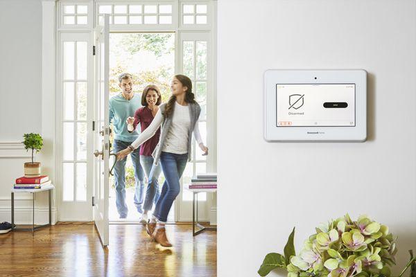 Family entering home with view of their security keypad