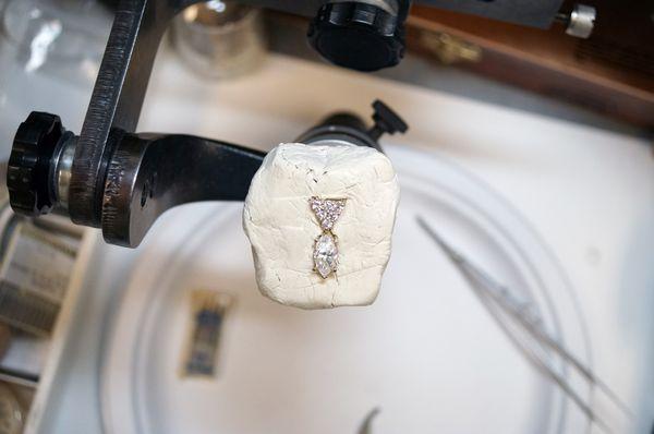 Jeweler setting large diamond in setting on-site location.