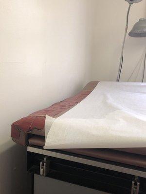 This is an examination bed in the practice. The floors had dirt and garbage cans were full. The place smelled.