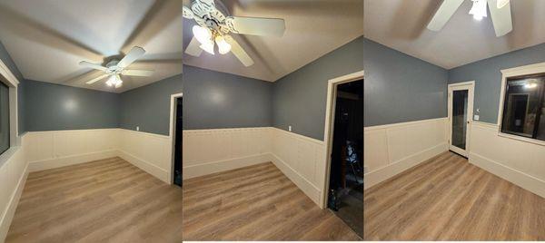 Finished room with new flooring, custom wall panels, fresh paint, and ceiling fan. Complete transformation.