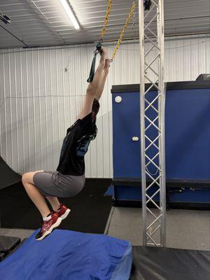 My son swinging from an obstacle.