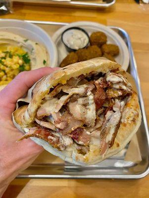 Warm pita filled with tender shawarma, creamy tahini and Mediterranean spice at Mazal Charleston.