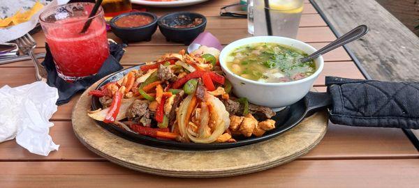 Fajita mix with chicken, steak and shrimp with a bowl of pinto beans. And a blended strawberry margarita.