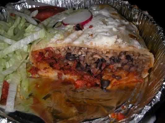 Side shot of the chorizo (Mexican sausage) chimichanga with salad