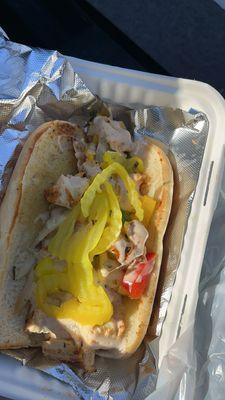 Grilled chicken hoagie with cheese, peppers and onions .