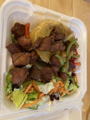 Carne frita con mofongo y ensalada.
