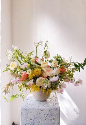 Spring flower arrangement with premium roses, sweetpea, and seasonal accent flowers.
