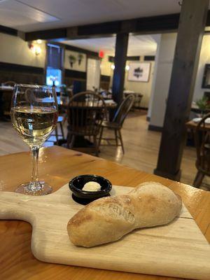 Warm bread, glass of wine and cozy setting
