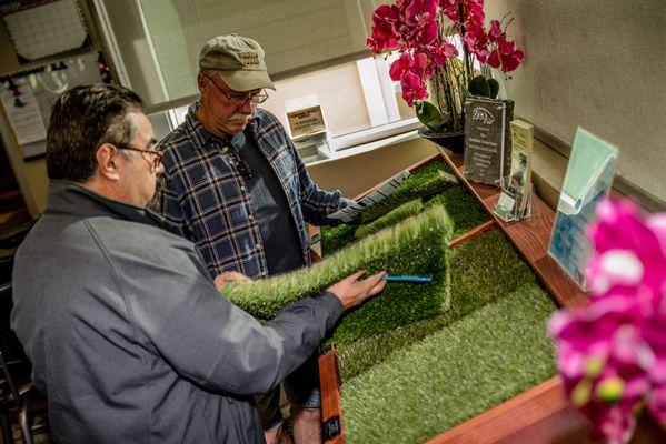 Two Arizona contractors are looking at different premium turfs on display in our North Phoenix & Scottsdale showroom.