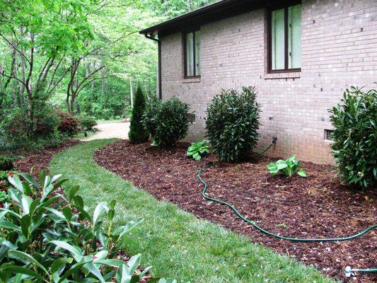 new design for homeowner included completed demolition of property, forming of shrubbery beds and setting plants, mulching, and laying sod
