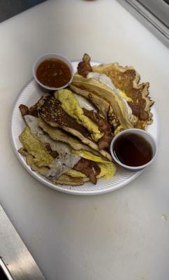 Breakfast tacos pancakes con huevo y tocino y queso bañados en miel