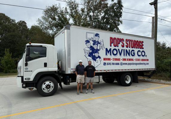 Owners, Pop and Alex, standing beside their new moving truck.
